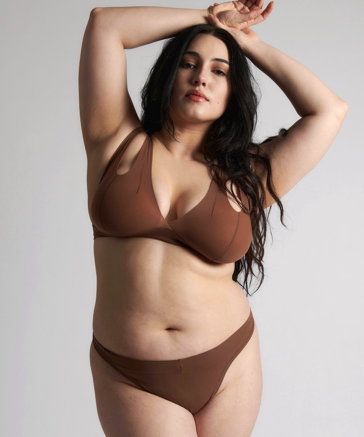Woman wearing a brown bra against a neutral background