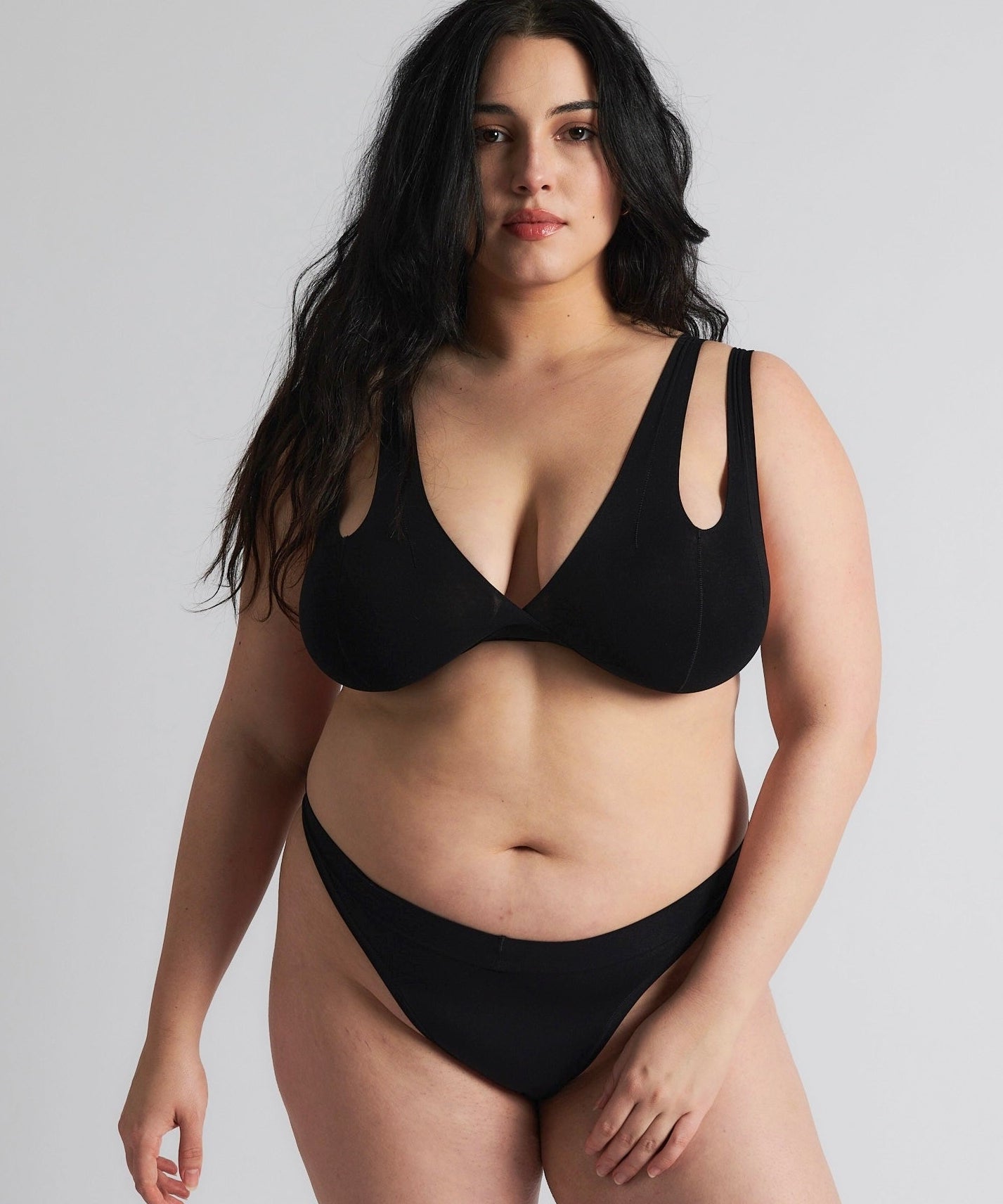 Woman wearing black tee system on plain background