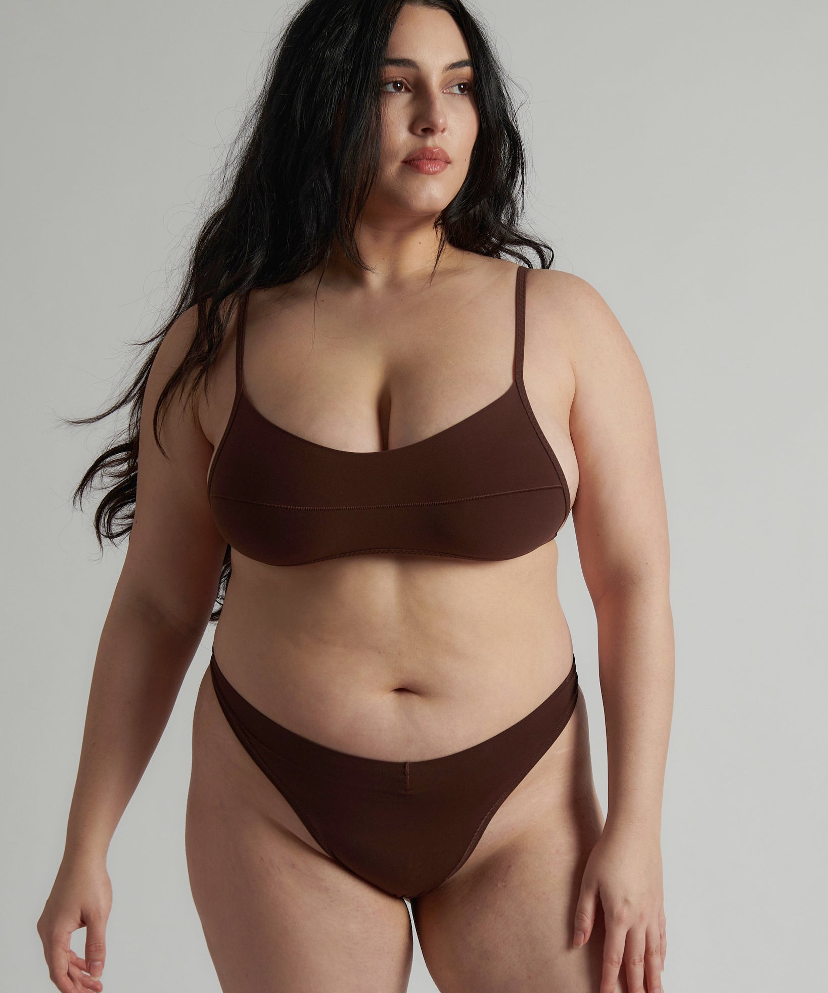 A person wearing a brown thong and scoop system on a plain background.