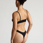 Person wearing a black cami system against a plain background