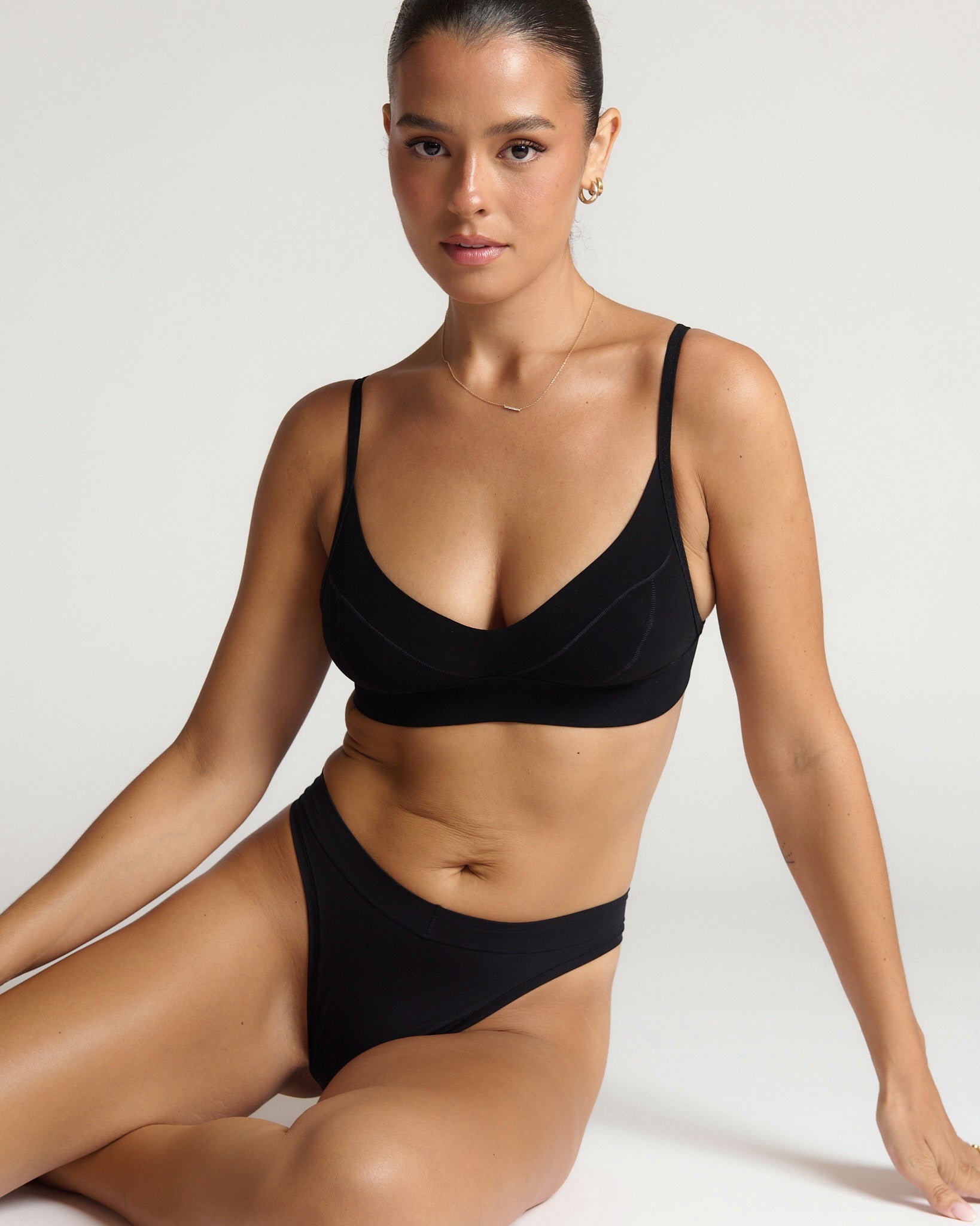 Person wearing a black cami system against a plain background