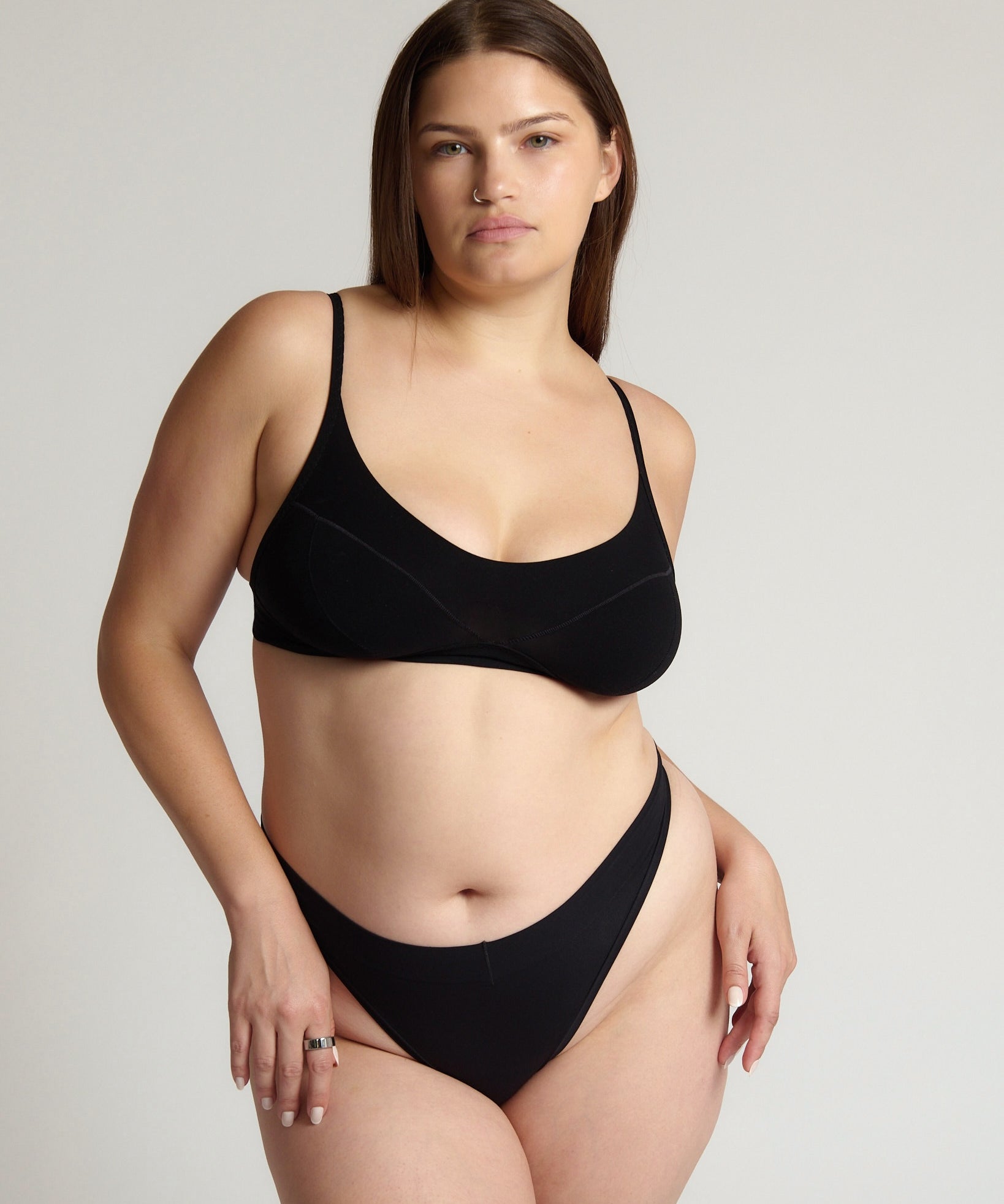 Person wearing a black cami system against a plain background