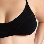 Black bra worn by a person on a neutral background