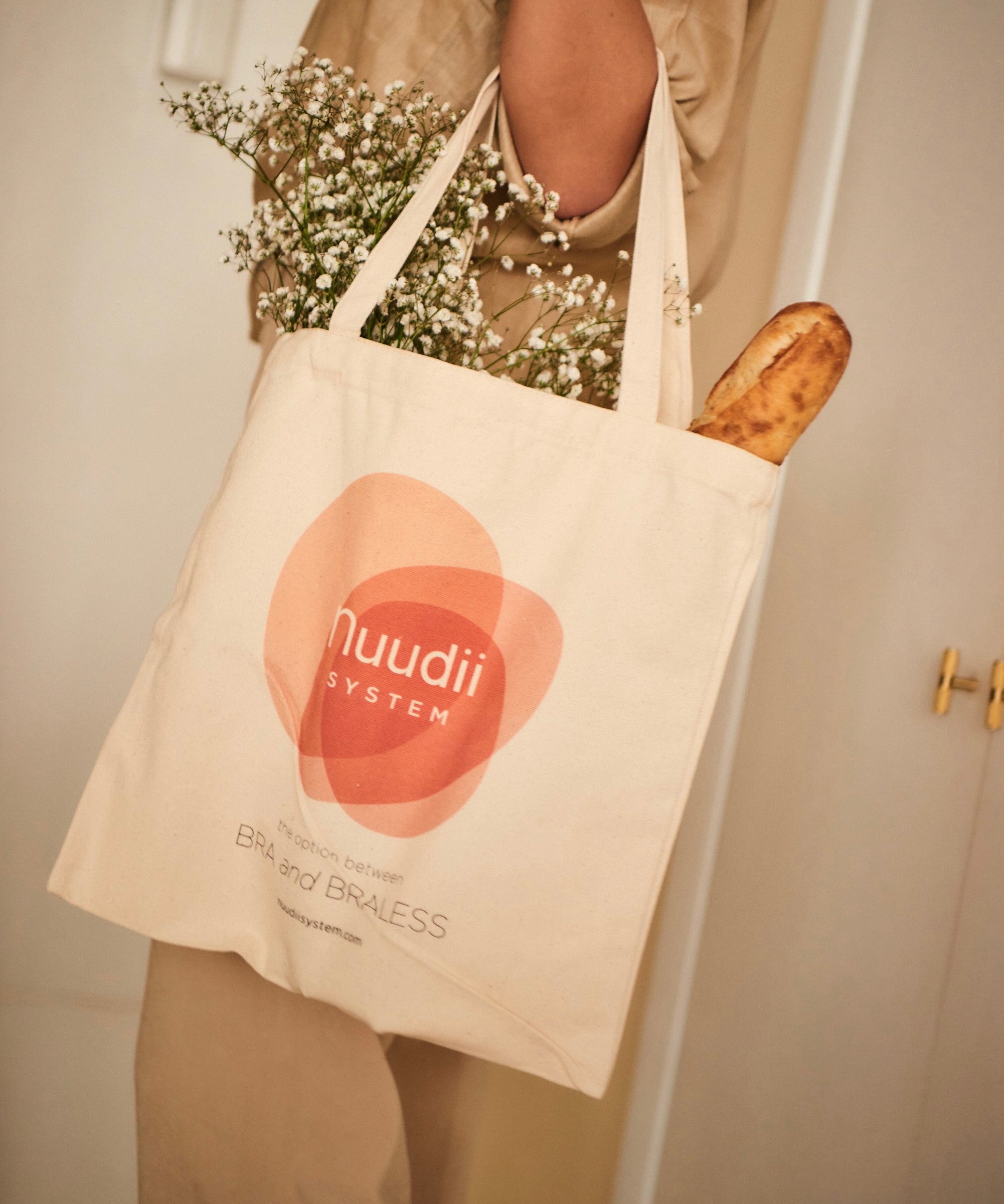 Woman holding Nuudii Boob Bag with flowers inside