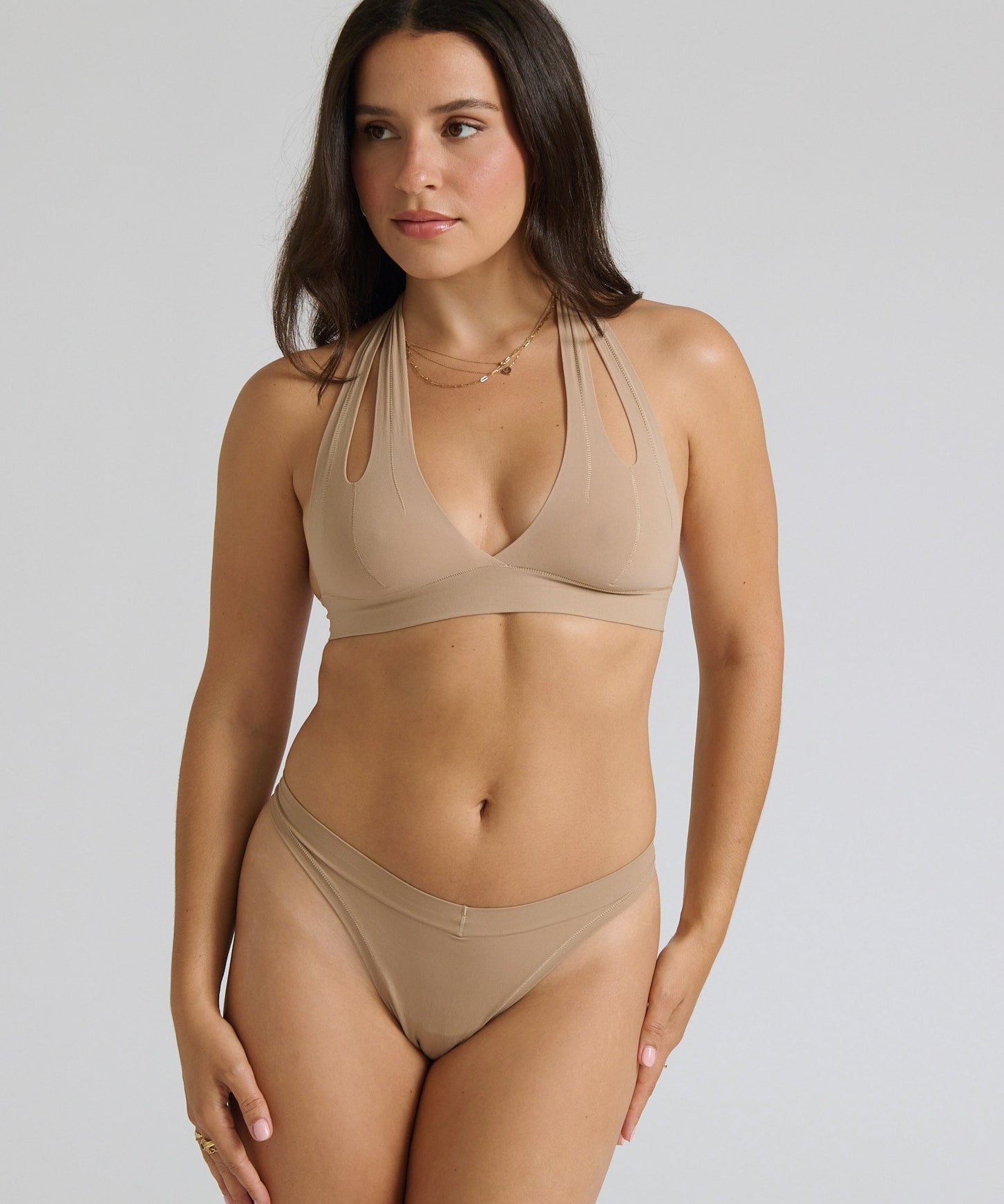 Beige halter system worn by a person on a plain background