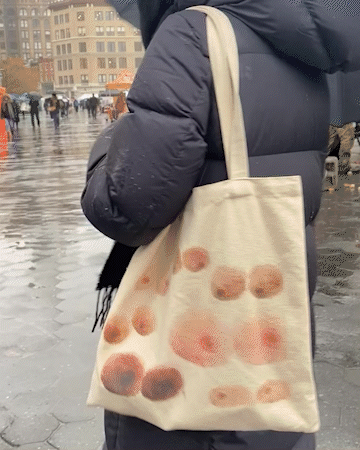 GIF of person walking in the rain carrying the Nuudii Boob Bag