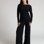 Woman wearing a black outfit on a plain background