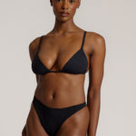 Black triangle bra worn by a model on a plain background