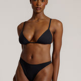 Black triangle bra worn by a model on a plain background