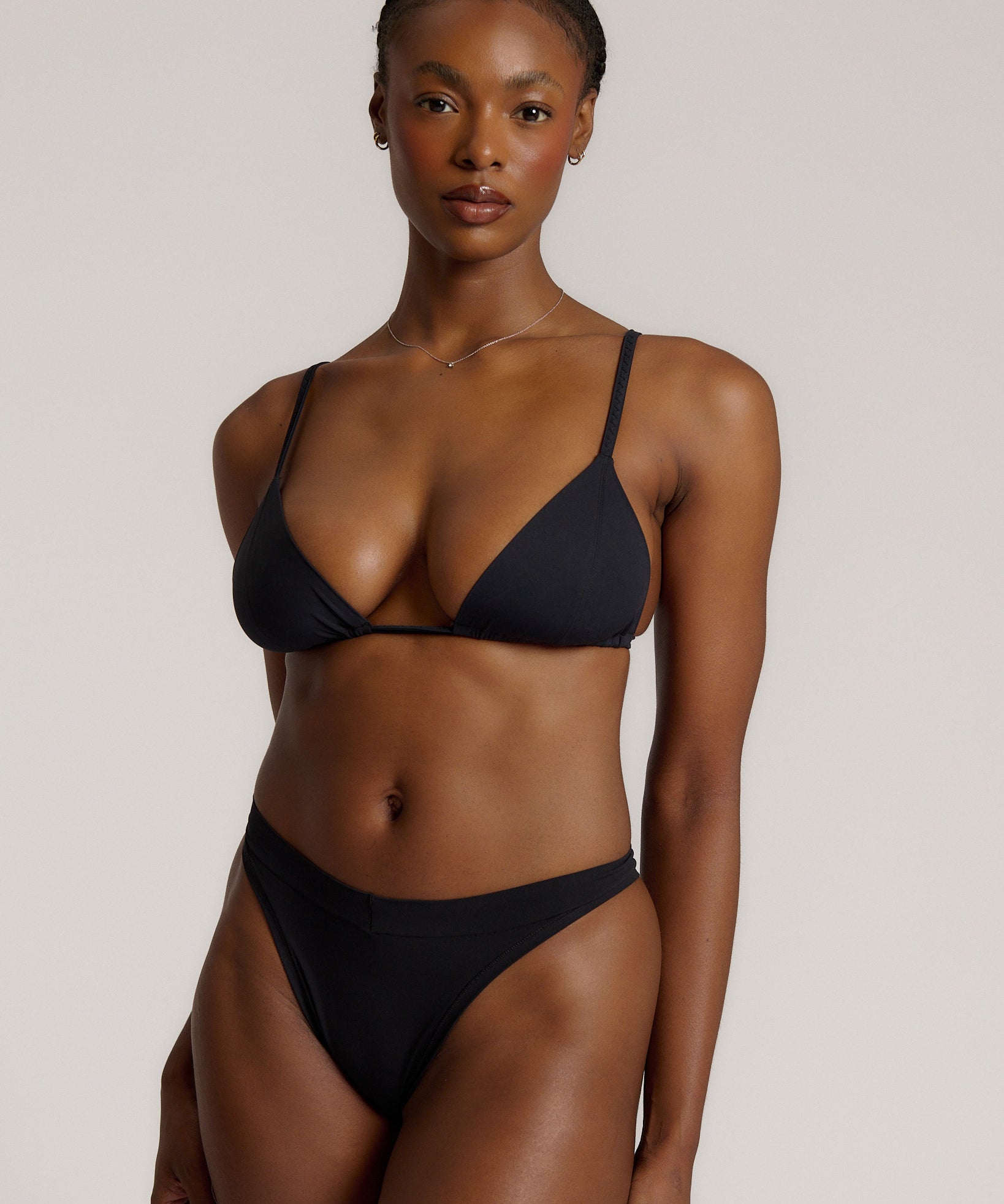 Black triangle bra worn by a model on a plain background