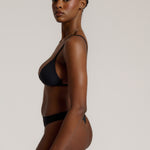 Black triangle bra worn by a model on a plain background
