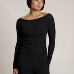 Woman wearing a black outfit on a plain background