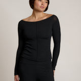 Woman wearing a black outfit on a plain background