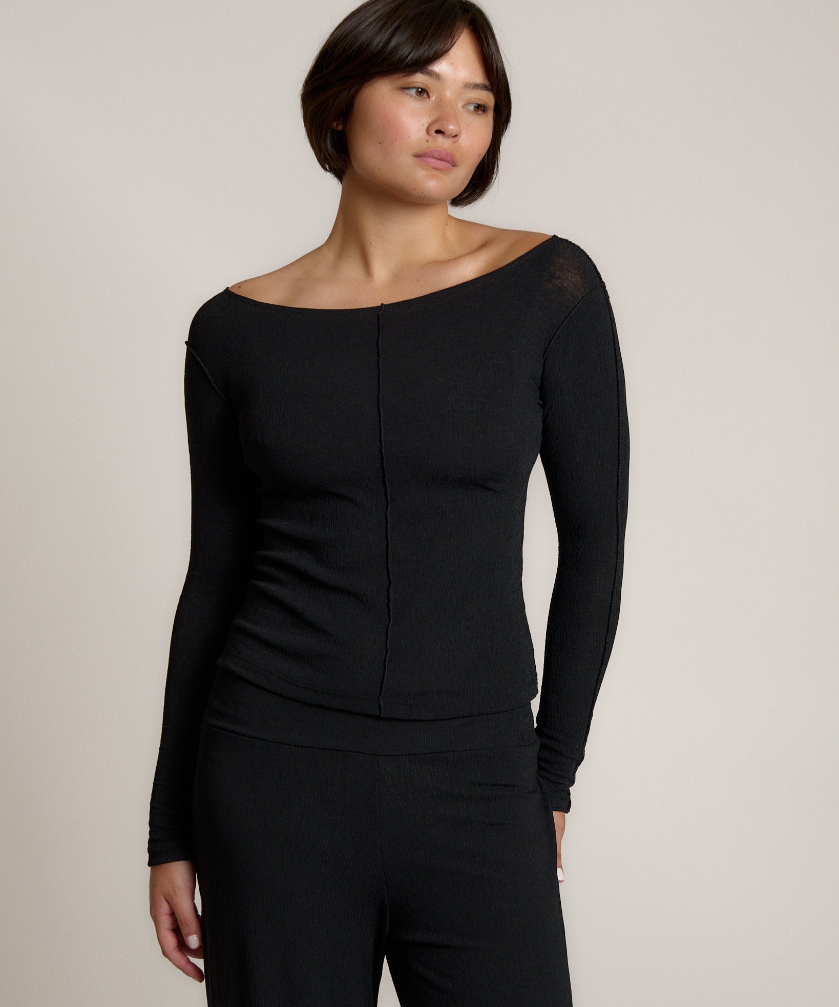 Woman wearing a black outfit on a plain background