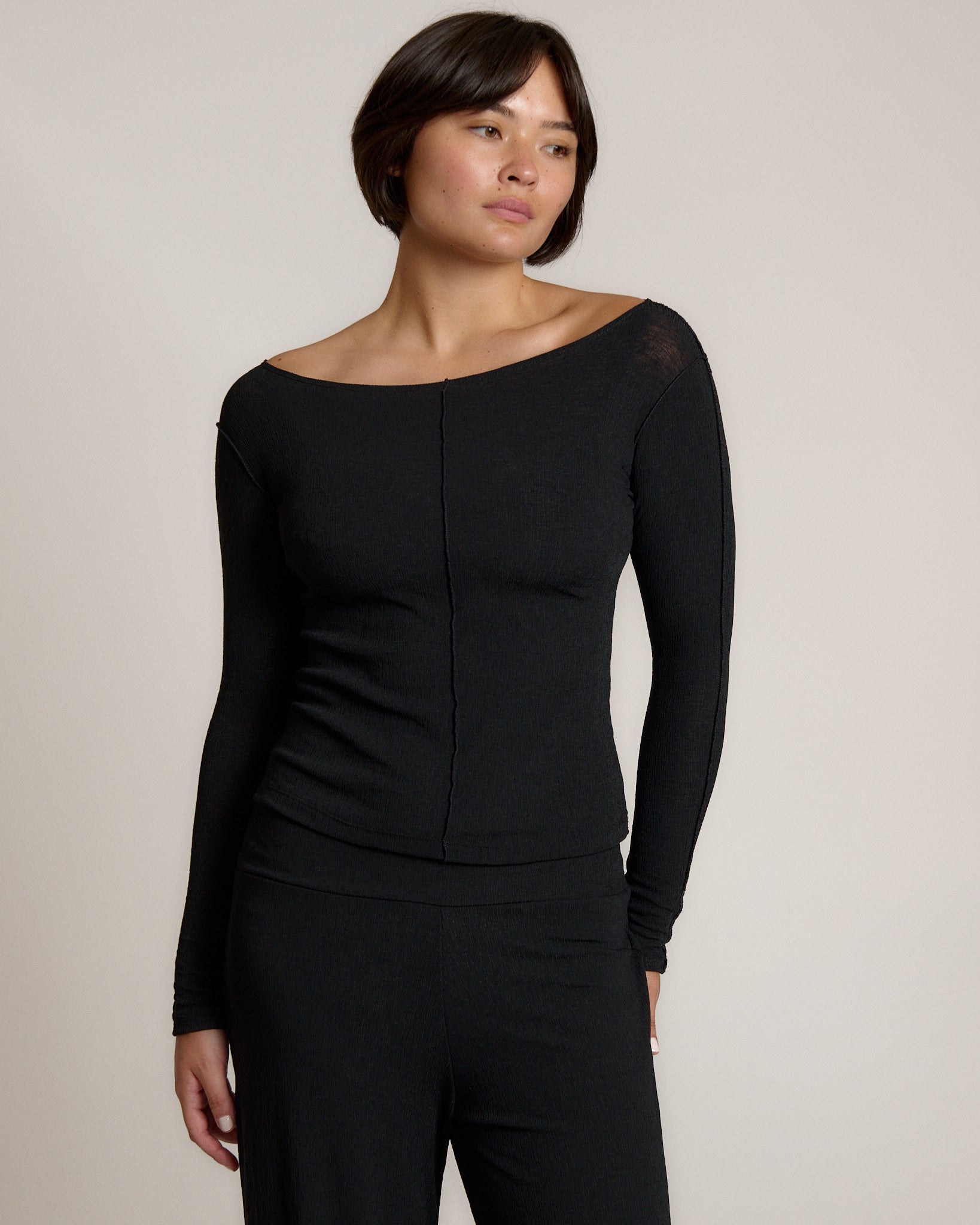 Woman wearing a black outfit on a plain background