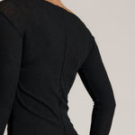 Woman wearing a black outfit on a plain background