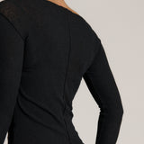 Woman wearing a black outfit on a plain background