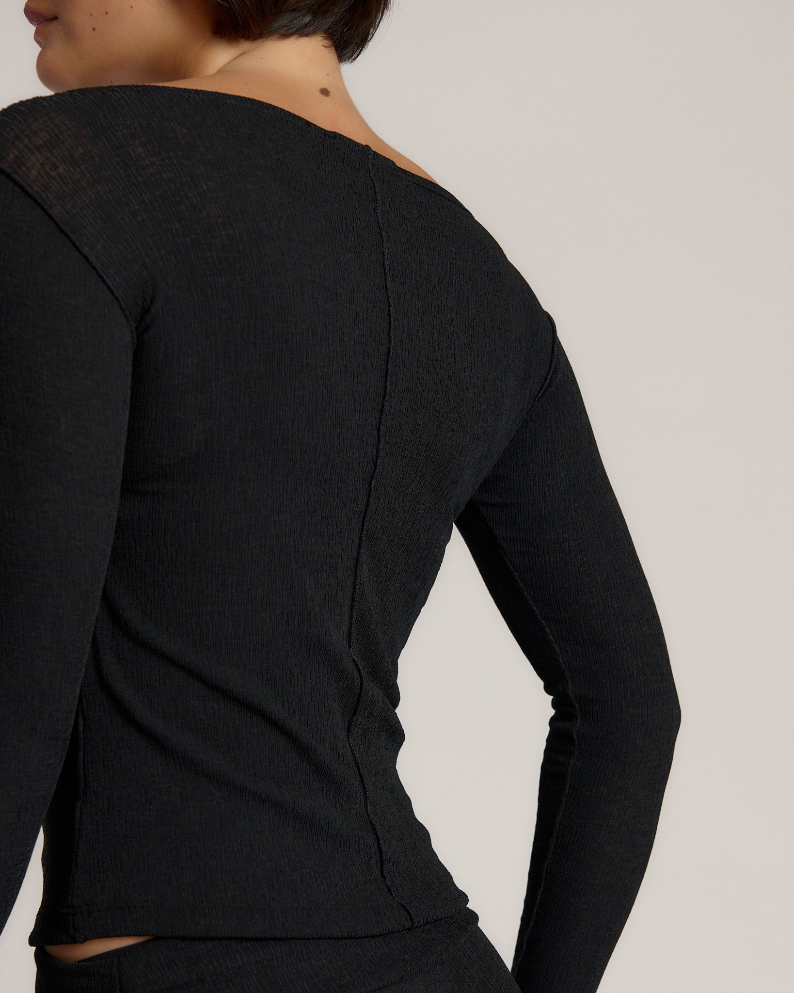 Woman wearing a black outfit on a plain background
