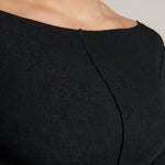 Woman wearing a black outfit on a plain background