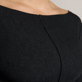 Woman wearing a black outfit on a plain background