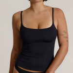 Woman wearing a cami top against a plain background