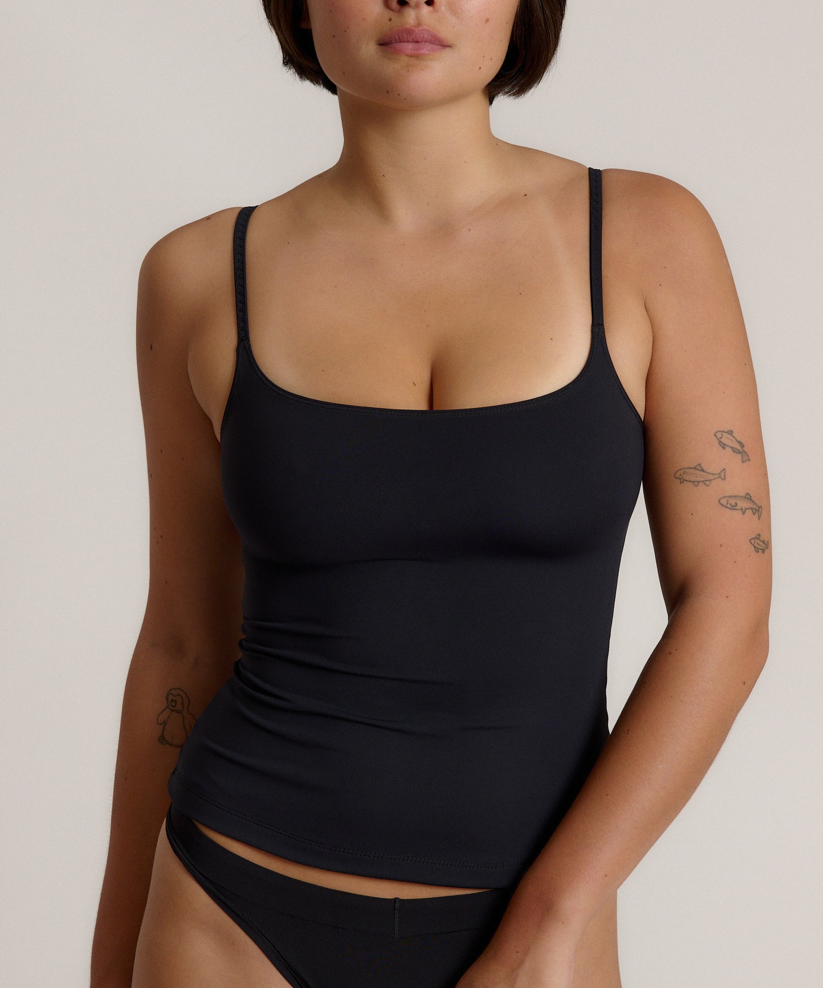 Woman wearing a cami top against a plain background