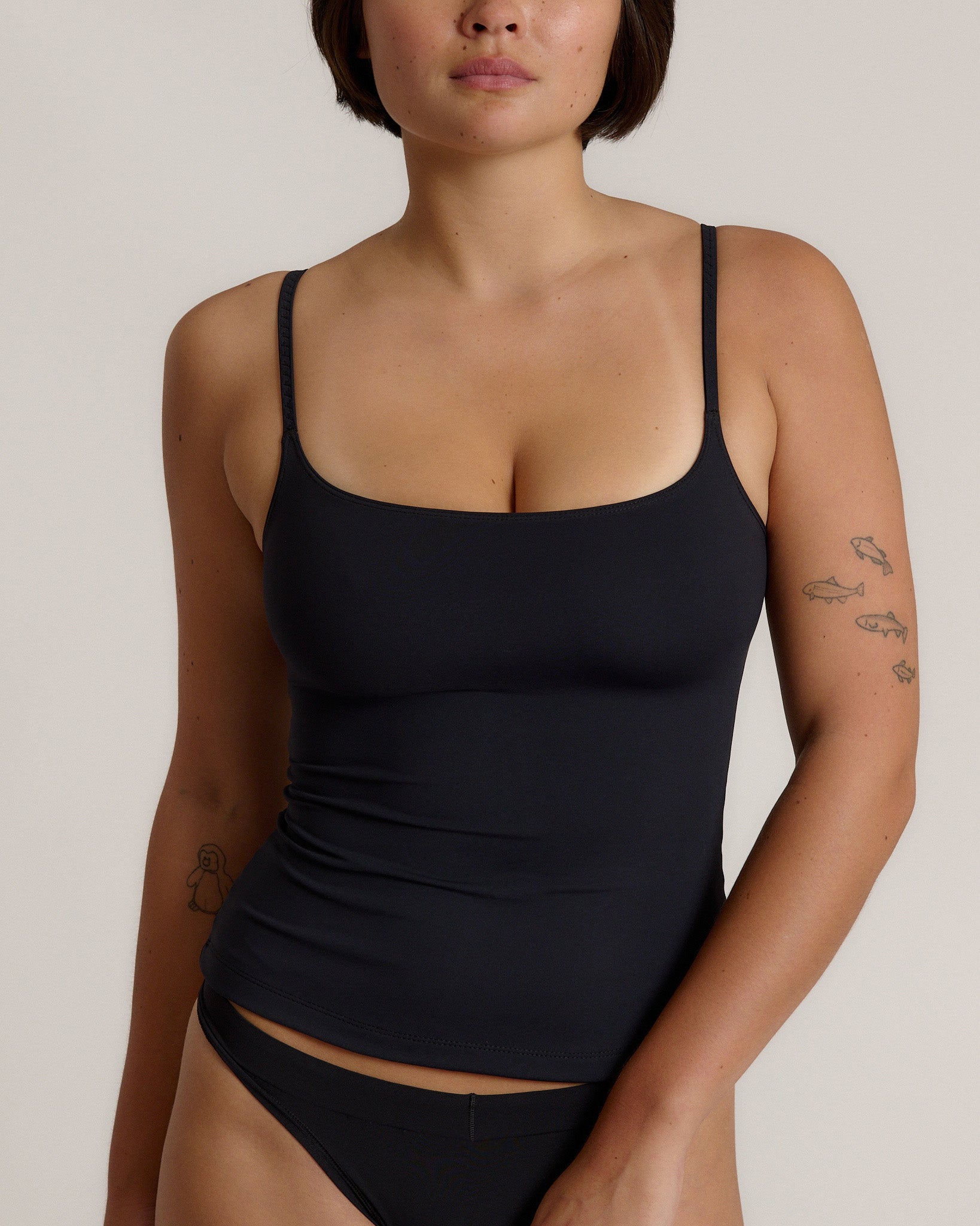 Woman wearing a cami top against a plain background