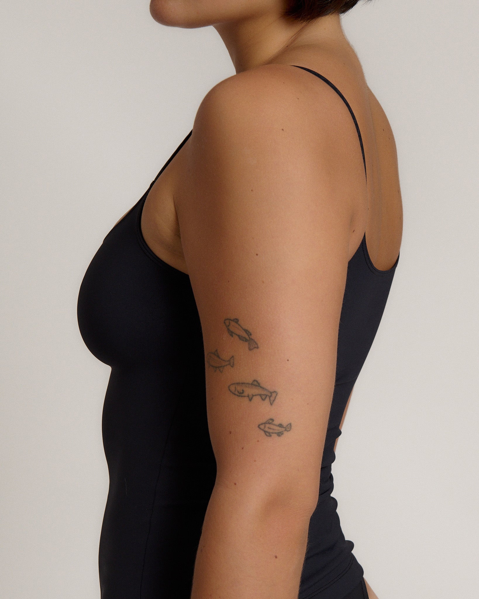 Woman wearing a cami top against a plain background