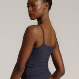 A woman modeling a myst cami and a matching thong against a plain light gray studio background.