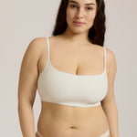Woman wearing a white bra and white underwear on a plain background