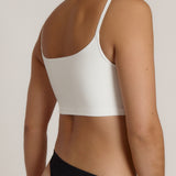 Woman wearing a white bra and white underwear on a plain background