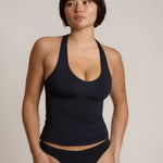 Woman wearing a black racerback against a plain background