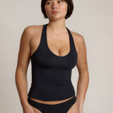 Woman wearing a black racerback against a plain background