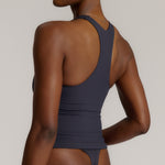 A woman modeling a myst racerback and a matching thong against a plain light gray studio background.