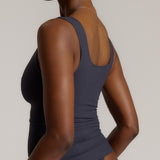 A woman modeling a myst scoop-neck tank top and a matching thong against a plain light gray studio background.