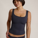 A woman modeling a myst scoop-neck tank top and a matching thong against a plain light gray studio background.