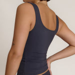 A woman modeling a myst scoop-neck tank top and a matching thong against a plain light gray studio background.