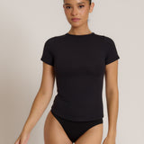 Woman wearing a black t-shirt against a plain background
