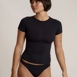 Woman wearing a black t-shirt against a plain background