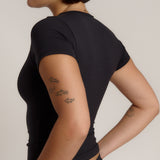 Woman wearing a black t-shirt against a plain background