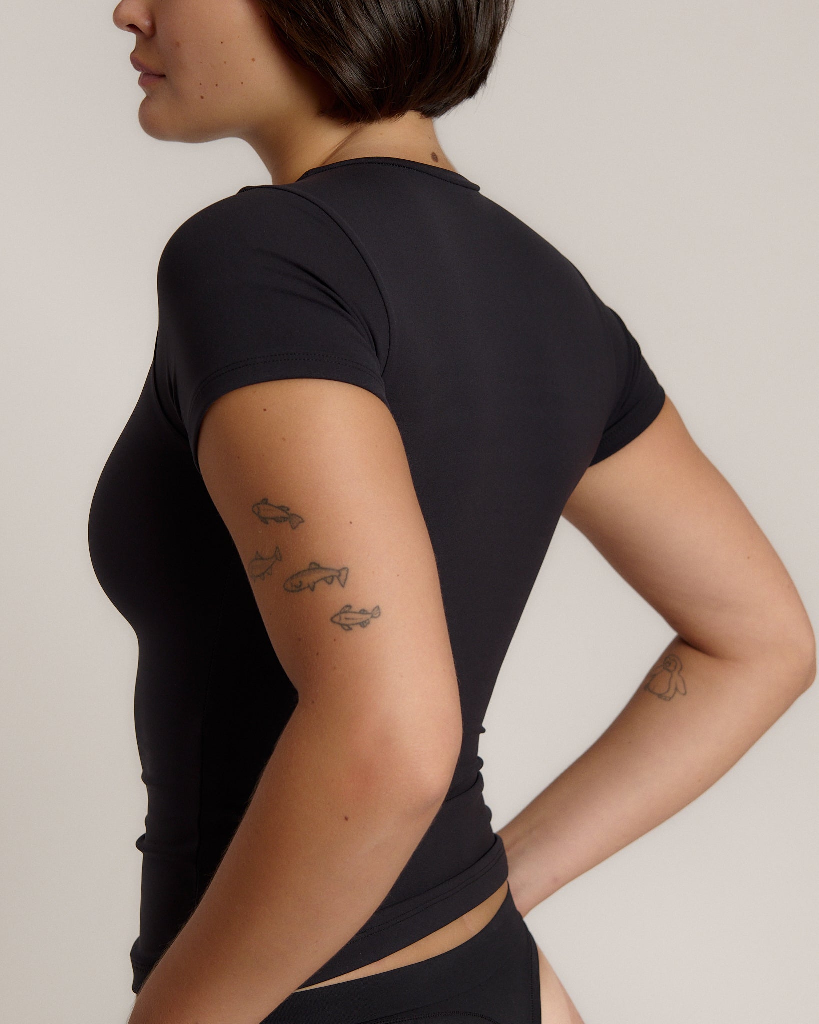 Woman wearing a black t-shirt against a plain background