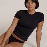 Woman wearing a black t-shirt against a plain background