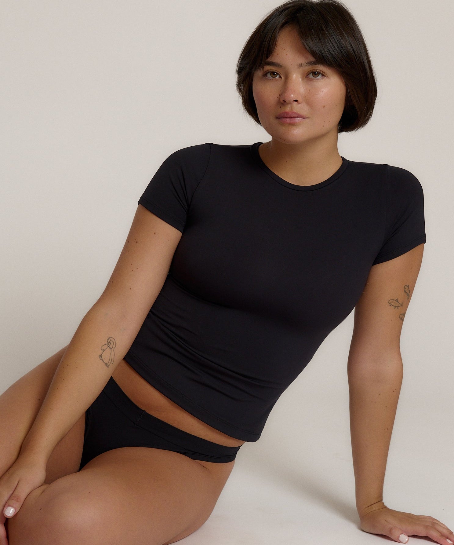Woman wearing a black t-shirt against a plain background