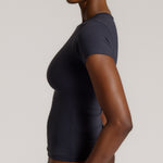 A woman modeling a myst tee and a matching thong against a plain light gray studio background.
