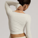 Woman wearing a white wrap top against a plain background