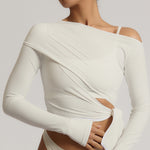 Woman wearing a white wrap top against a plain background