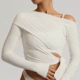 Woman wearing a white wrap top against a plain background