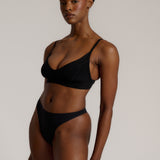 Person wearing a black cami system against a plain background