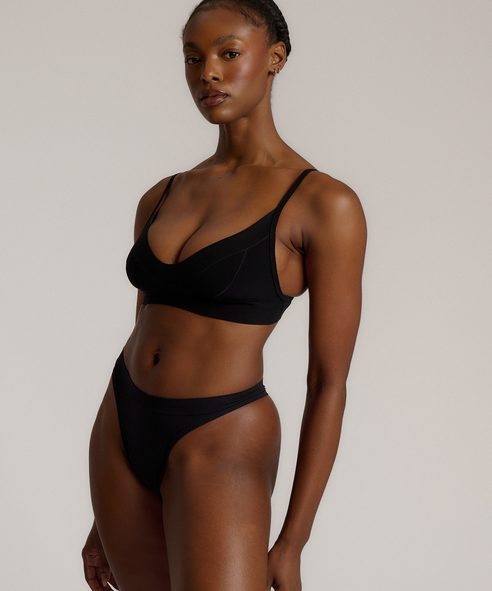 Person wearing a black cami system against a plain background