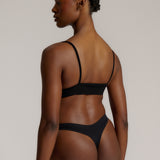 Person wearing a black cami system against a plain background